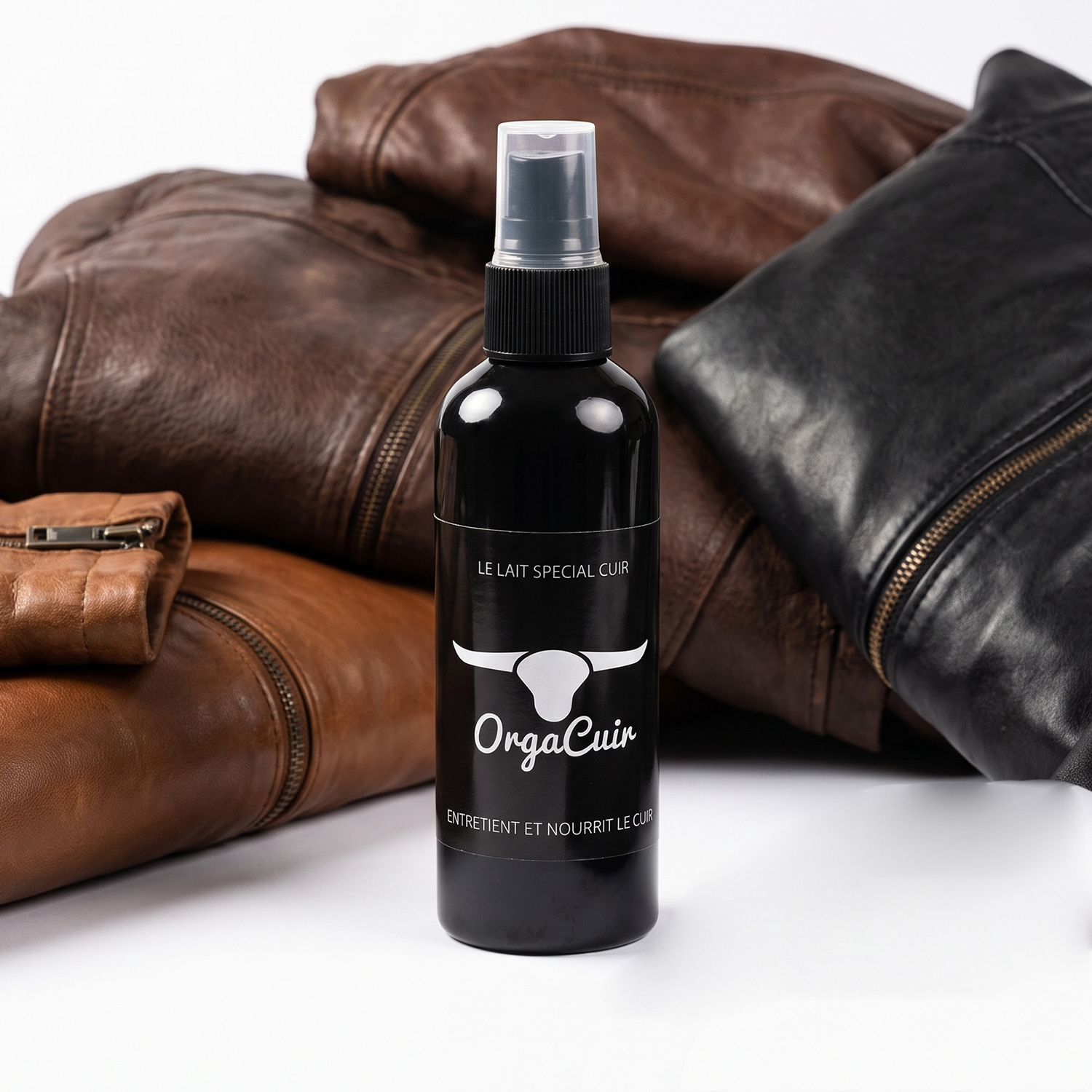 Spray nourrissant cuir Orga Cuir 60 ml posé devant des vestes en cuir